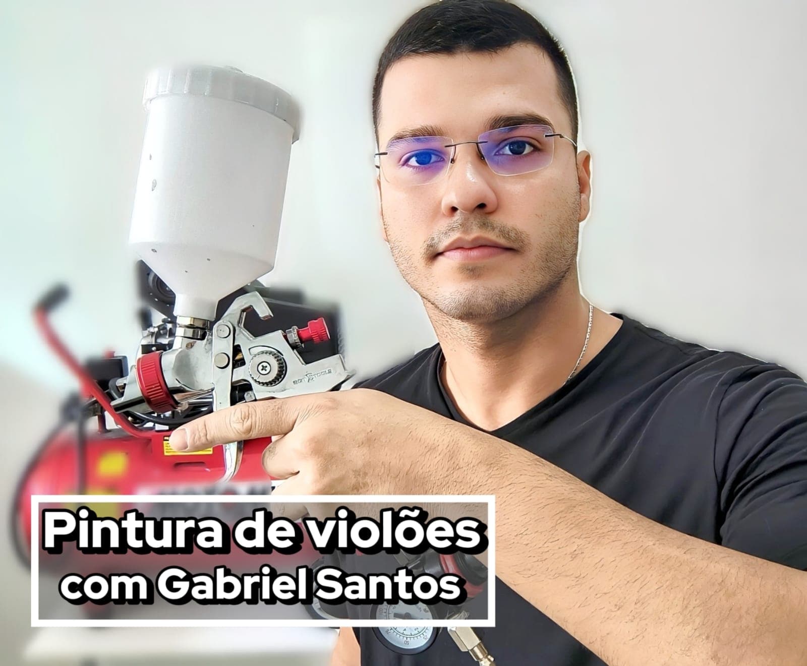 Gabriel Santos segurando uma pistola de pintura ao lado de um compressor de ar — capa do curso de pintura de violões